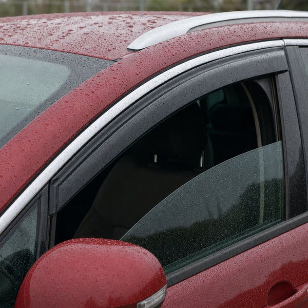 Déflecteur d'air fumé fixé en haut de la porte avant d'un Peugeot 3008 rouge, vitre baissée sous la pluie