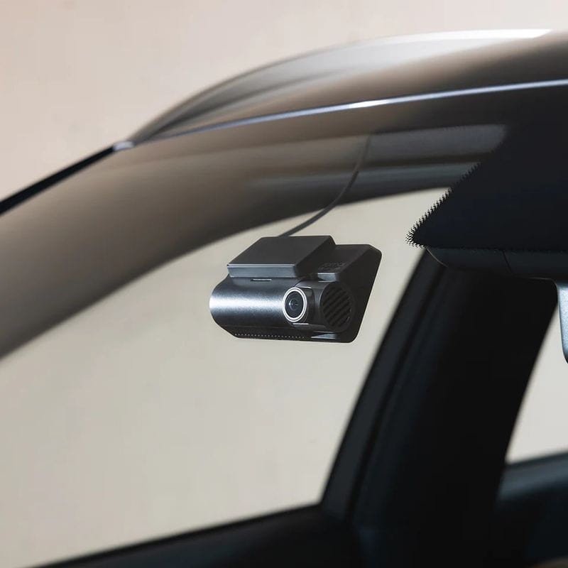 Dashcam installée au pare-brise d'une voiture, derrière le rétroviseur intérieur