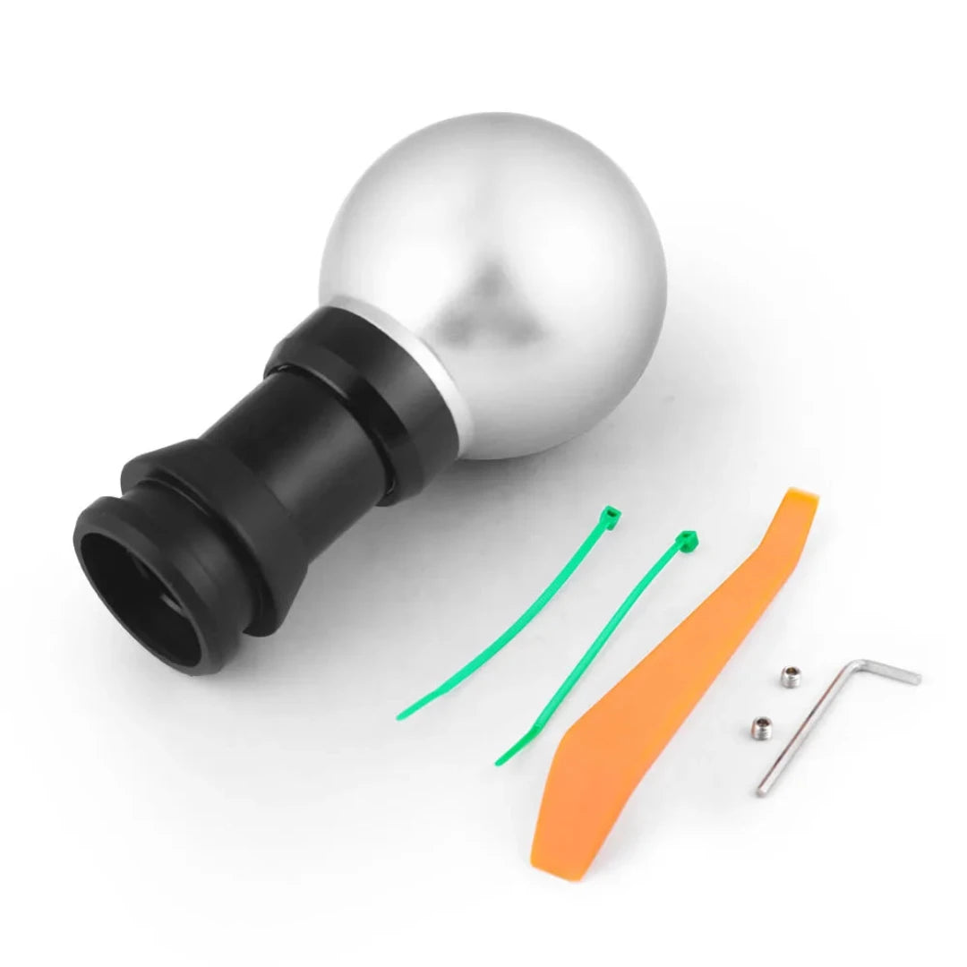 Pommeau de vitesse Mazda CX, de couleur gris, accompagné de ses équipements pour démonter le pommeau.