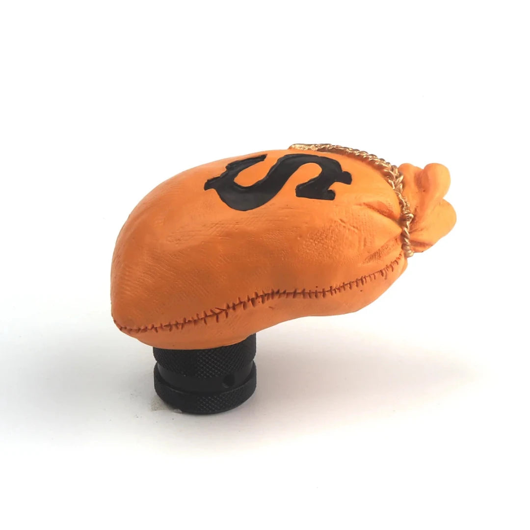 Pommeau de vitesse en forme de sac de billets de couleur orange, avec le logo dollar dessus.