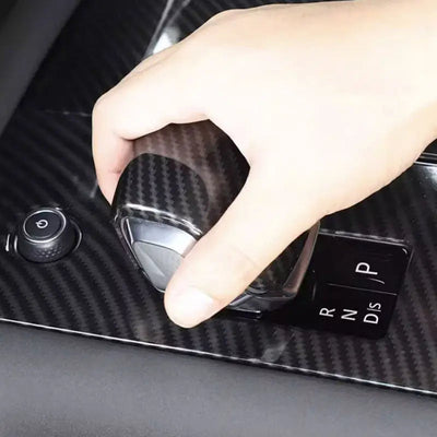 Main sur le sélecteur équipé du cache pommeau de vitesse carbone, dans un Range Rover