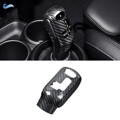 Cache pommeau de vitesse en fibre de carbone monté sur le sélecteur automatique d'une Mini Cooper, avec la pièce seule en dessous