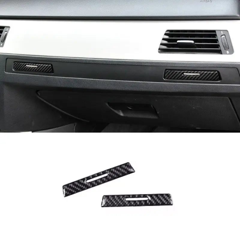 Deux caches carbone posés sur les poignées de porte-gobelets passager d'une BMW E90