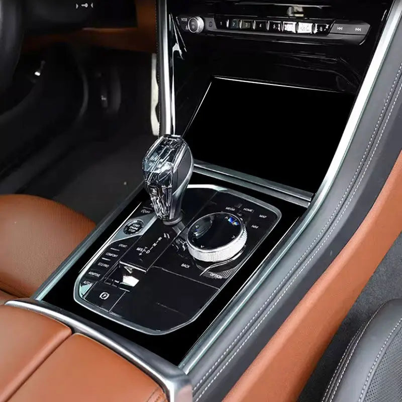 Console centrale de BMW Série 8 G15 avec la garniture noir laqué autour du levier et de la molette iDrive