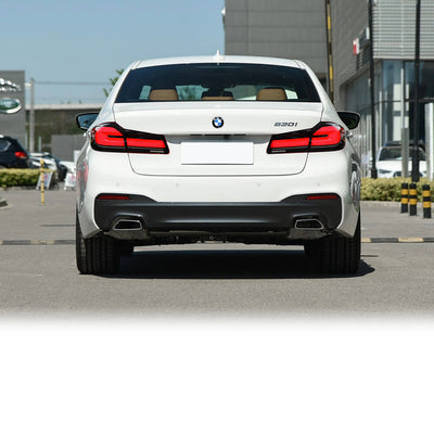 BMW 530i G30 blanche vue de l'arrière avec les feux LED allumés