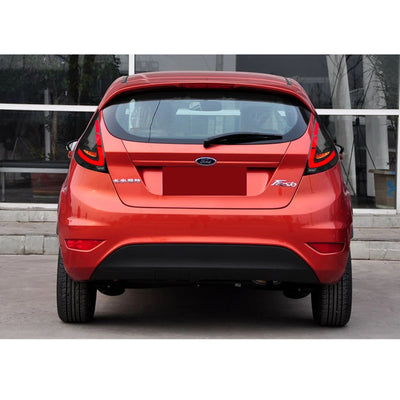 Ford Fiesta rouge vue de l'arrière avec les feux LED fumés noirs allumés