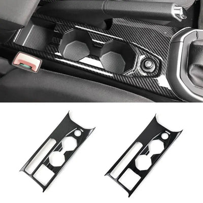 Garniture console centrale Polo 6 en finition carbone montée autour des porte-gobelets, avec les versions carbone et noir laqué présentées dessous