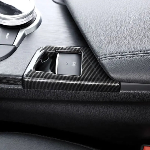 Garniture carbone montée autour du bouton de frein à main électrique d'une Alfa Romeo Giulia