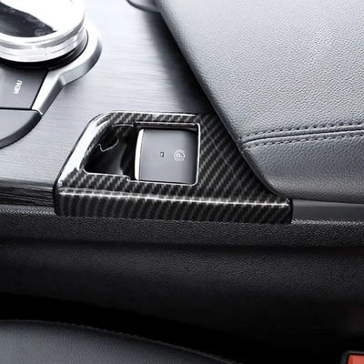 Garniture carbone montée autour du bouton de frein à main électrique d'une Alfa Romeo Giulia