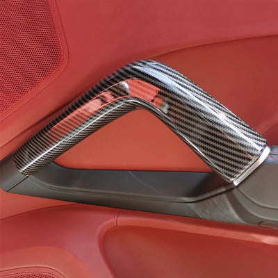 Garniture poignée de porte carbone montée sur un panneau de porte rouge de Porsche Cayenne 958