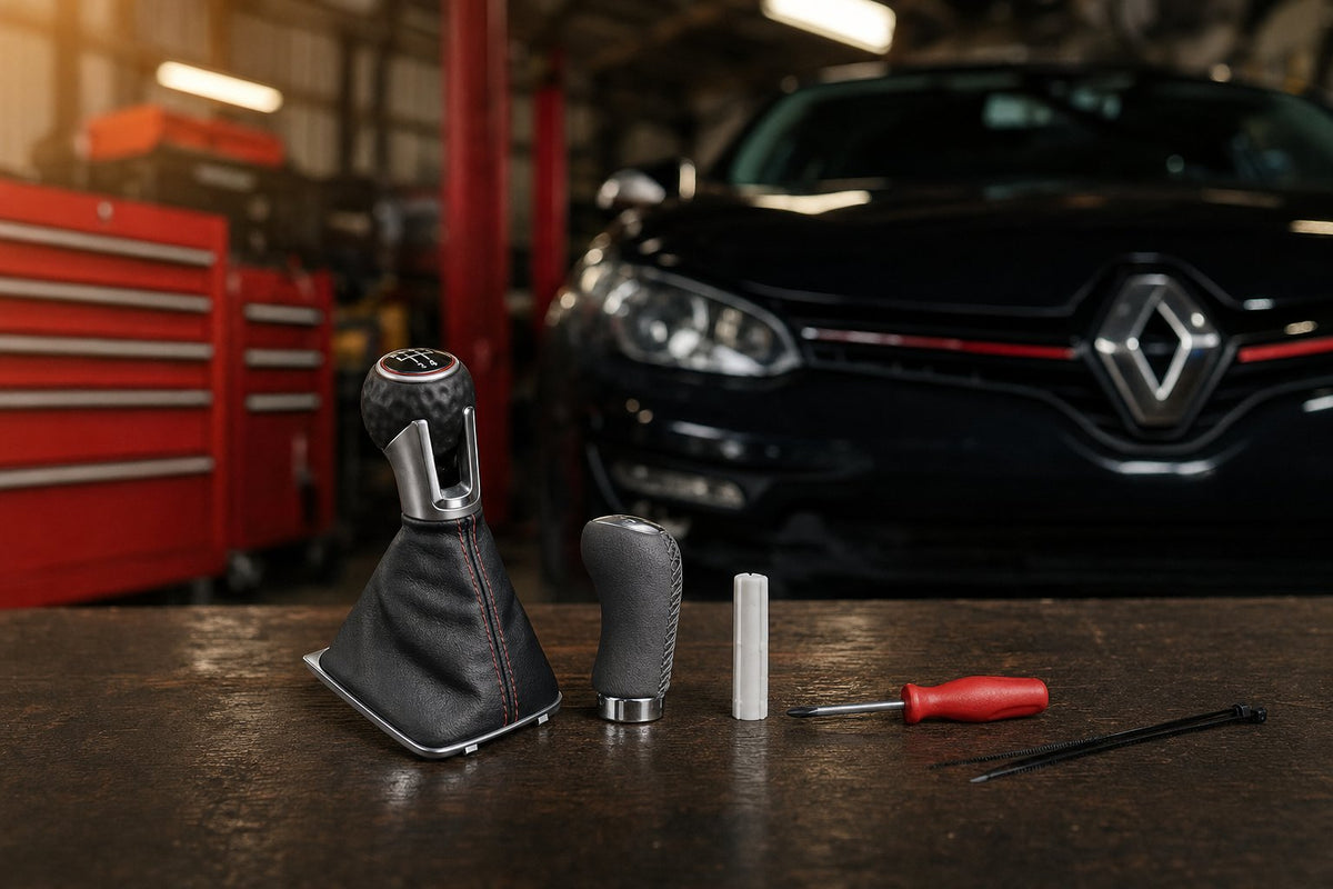 Pommeaux de vitesse, adaptateur et soufflet sur un établi d'atelier devant une Renault Mégane