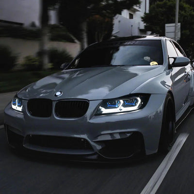 BMW Serie 3 E90 grise en mouvement, phares LED allumés