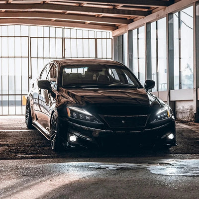 Lexus IS noire équipée des phares LED, projecteurs allumés