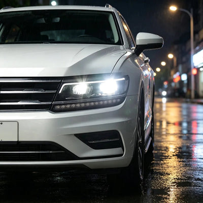 Phare LED Tiguan allumé de nuit sous la pluie sur un SUV blanc