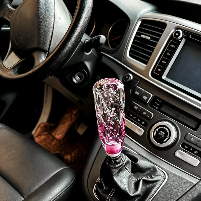 Pommeau acrylique transparent teinté rose monté sur un levier de vitesse