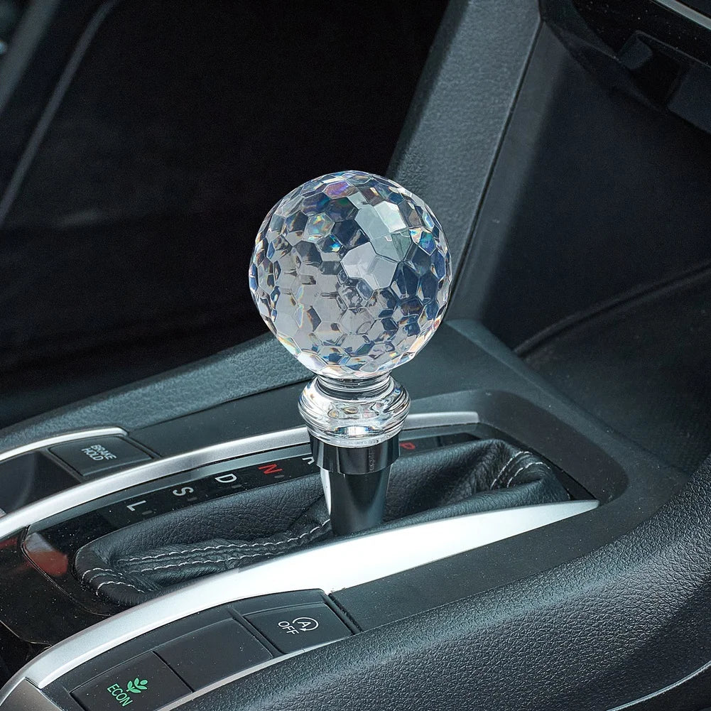Gros plan sur le pommeau de vitesse Crystal, sphère transparente à facettes et embase chromée