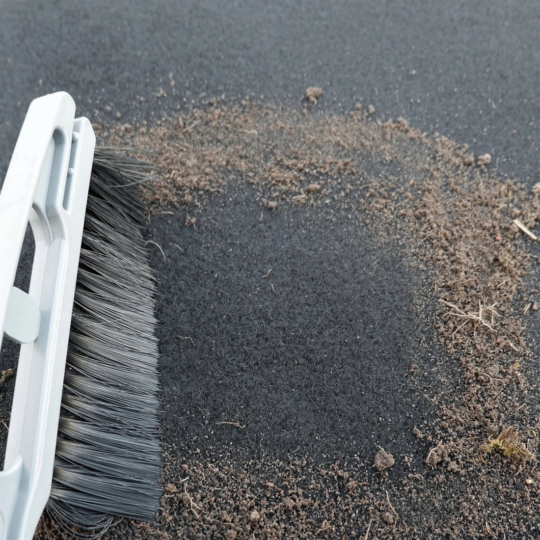 Brosse de la raclette offerte nettoyant un tapis de sol voiture