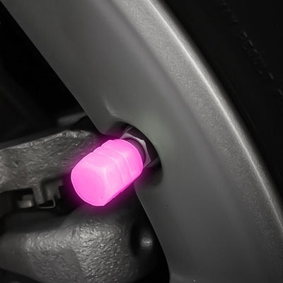 Bouchon de valve lumineux rose monté sur la valve d'une jante, de nuit