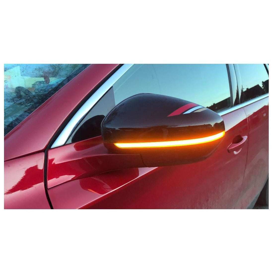Clignotant dynamique monté sur le rétroviseur d'une Peugeot 3008 rouge, bandeau LED orange allumé