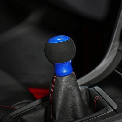 Pommeau de vitesse bleu monté sur le levier, sphère en suédine noire et embase bleue pétillée