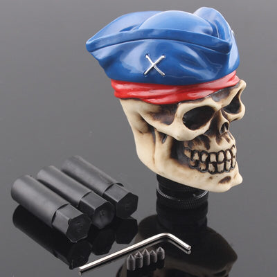Pommeau de vitesse crâne pirate en second, béret bleu à sabres croisés et bandeau rouge sur le front