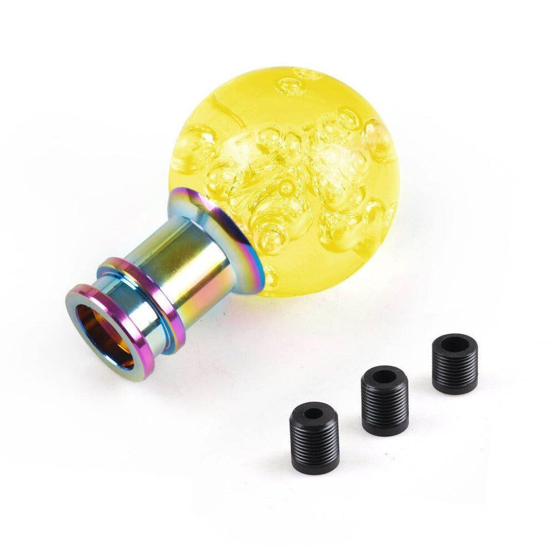 Pommeau de vitesse original en forme de boule, de couleur jaune.