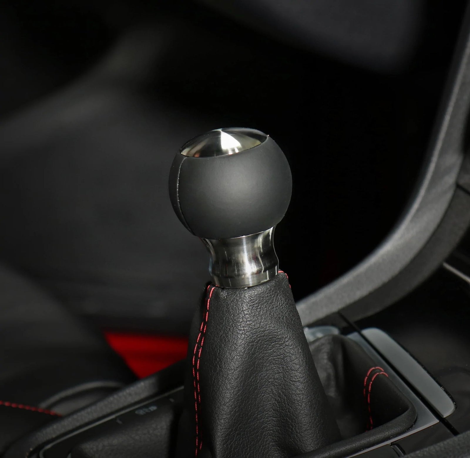 Pommeau de vitesse poli monté sur le levier, sphère en suédine noire et embase en inox brossé