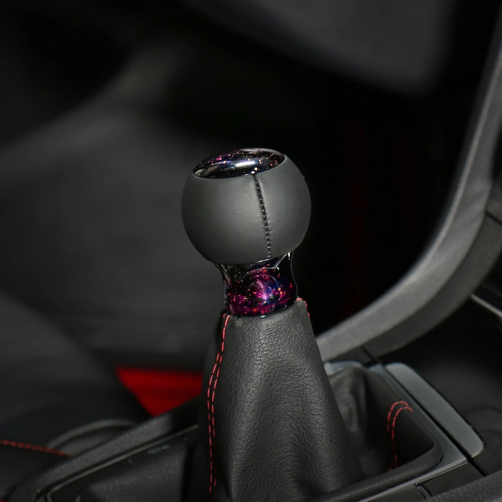 Pommeau de vitesse violet étoilé installé sur le levier, sphère noire et embase violet nébuleuse