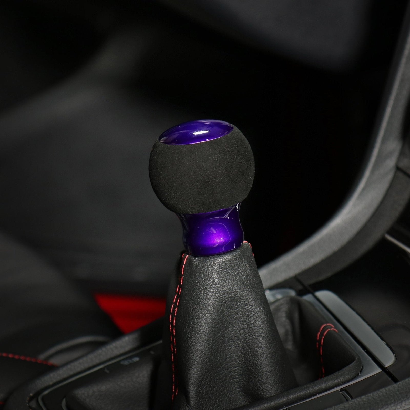 Pommeau de vitesse violet installé sur le levier, sphère suédine noire et embase violette brillante