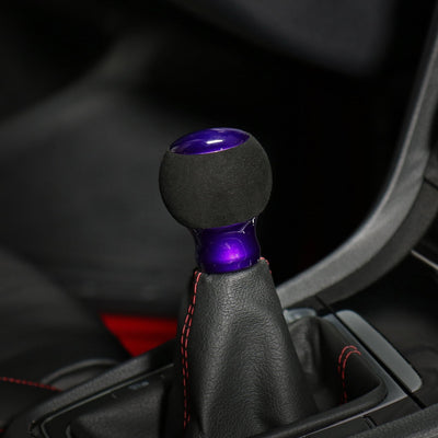 Pommeau de vitesse violet installé sur le levier, sphère suédine noire et embase violette brillante